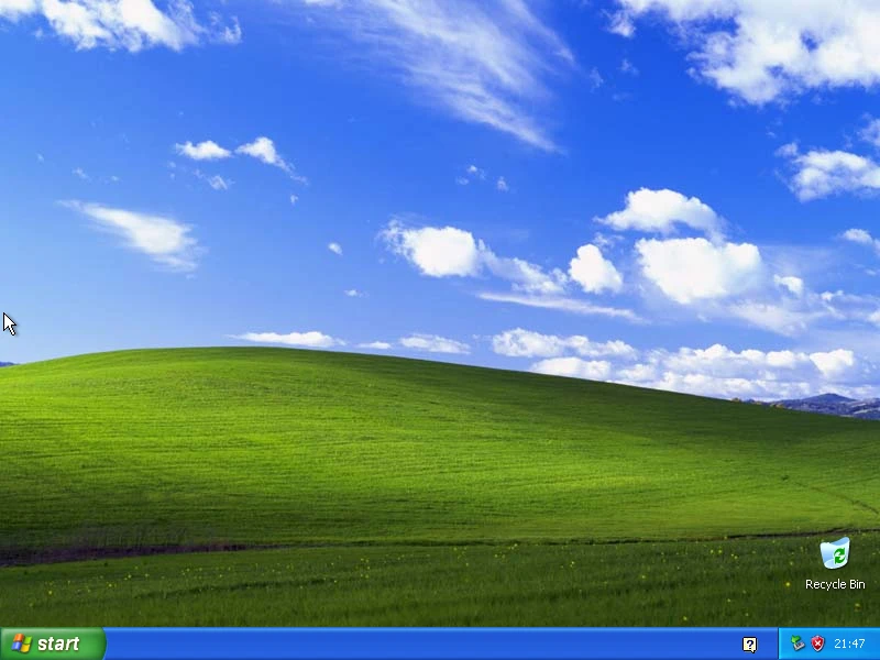 Windows 2000 sur la machine de référence : Le bureau au démarrage : fond uni, cinq icônes, barre des tâches classique